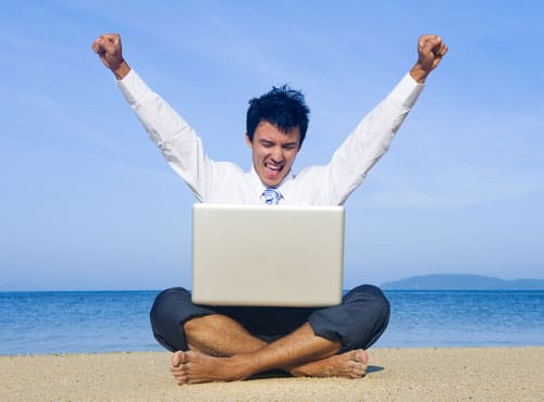 Image d'un homme heureux sur la plage en train de travailler