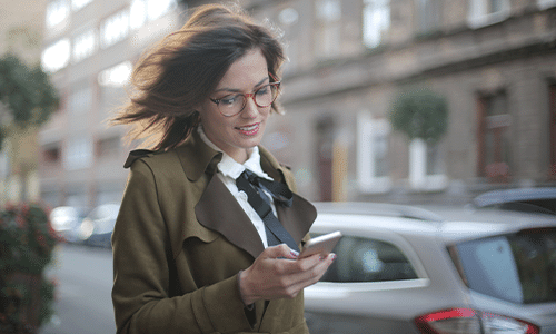 Image d'une femme sur son smartphone dehors